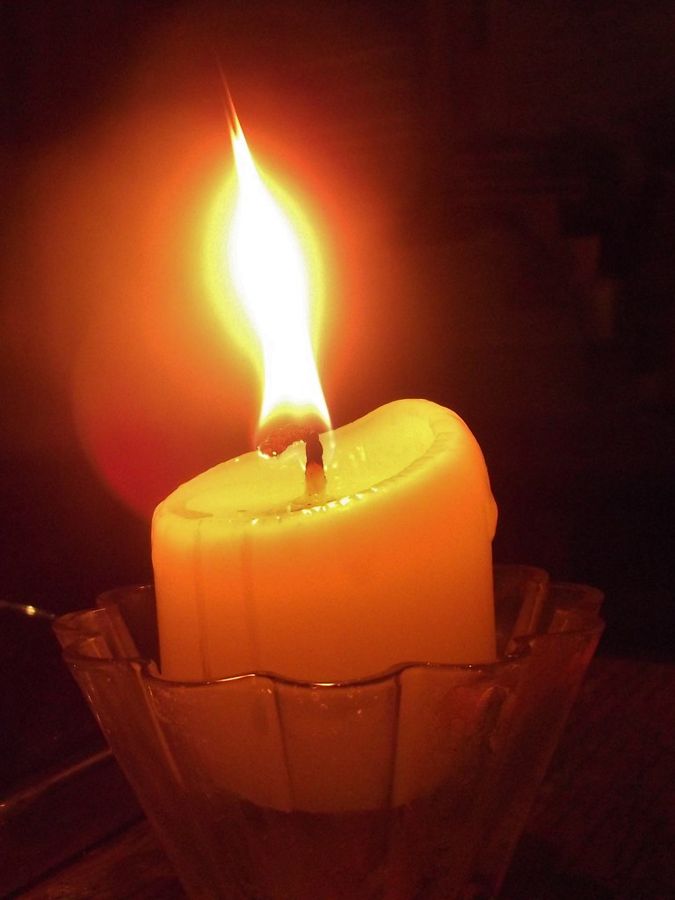The Gratitude Amber Jar candle, lit and glowing