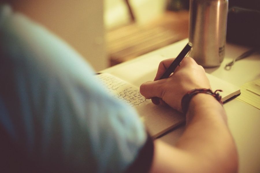 Writing a reflection in a journal by warm light