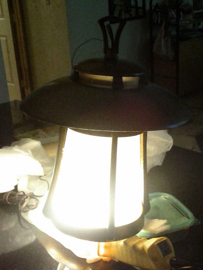 The Serenity Pillar Candle glowing warmly inside a lantern
