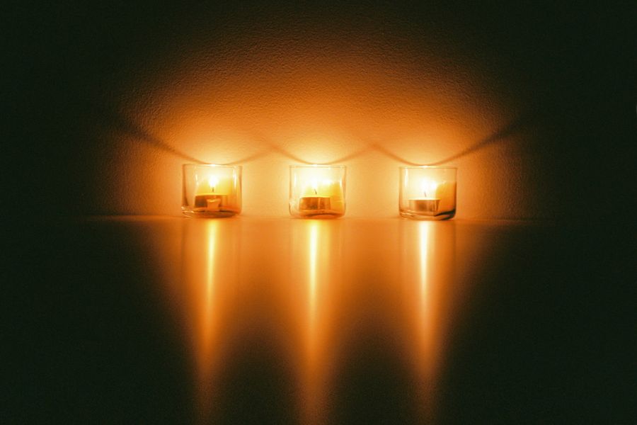 Lit tealights glowing in hanging glass holders